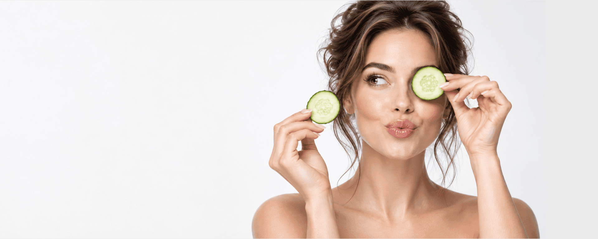 Woman holding cucumber slices during her skincare routine